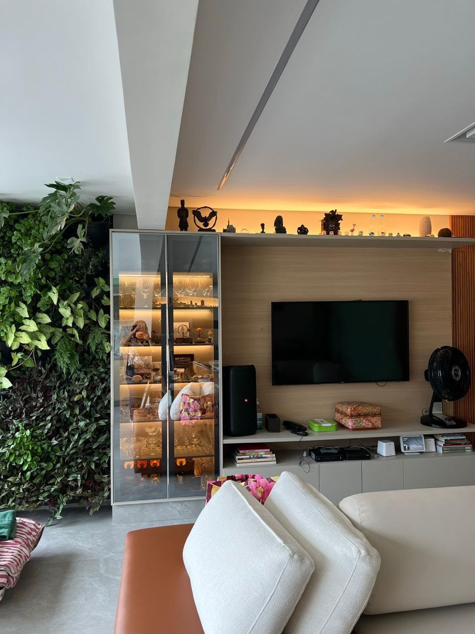 Sala com painel de TV e estante de madeira iluminada