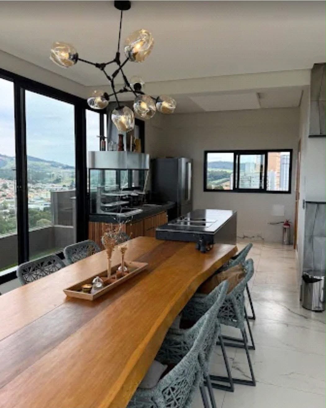 Mesa de jantar de madeira em varanda integrada à cozinha