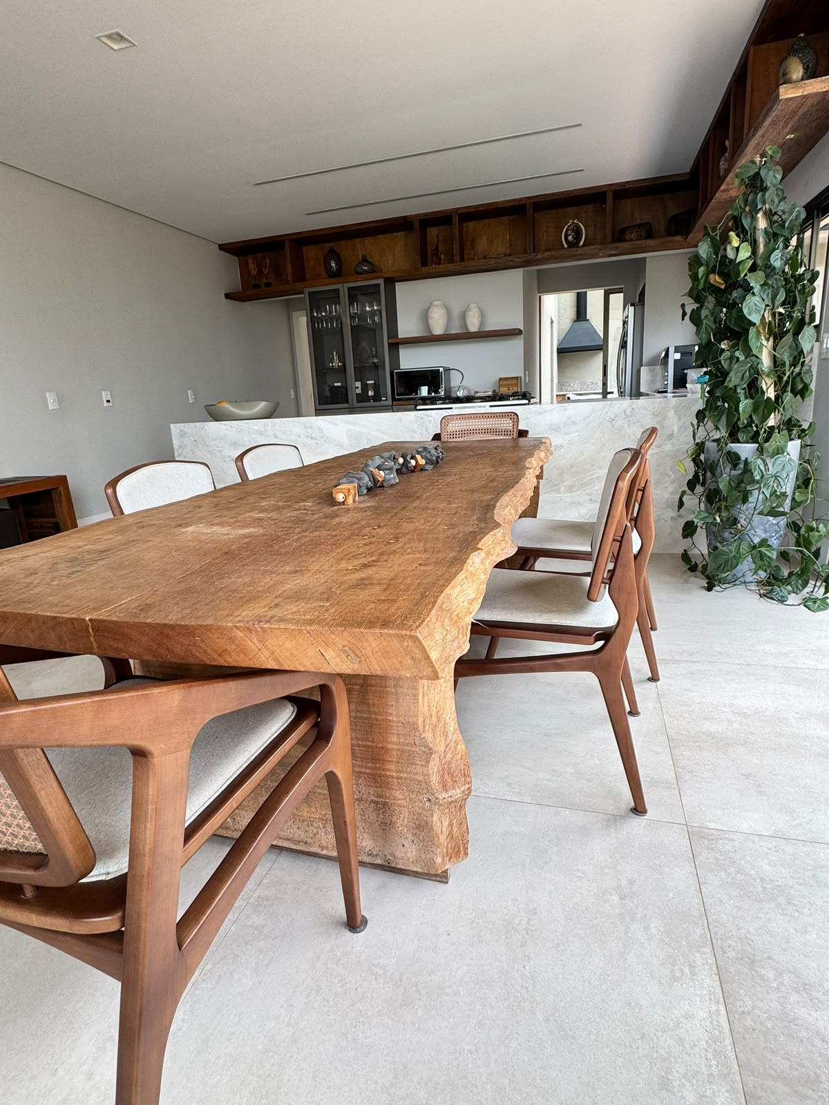 Mesa de madeira maciça com bordas naturais e cadeiras de madeira