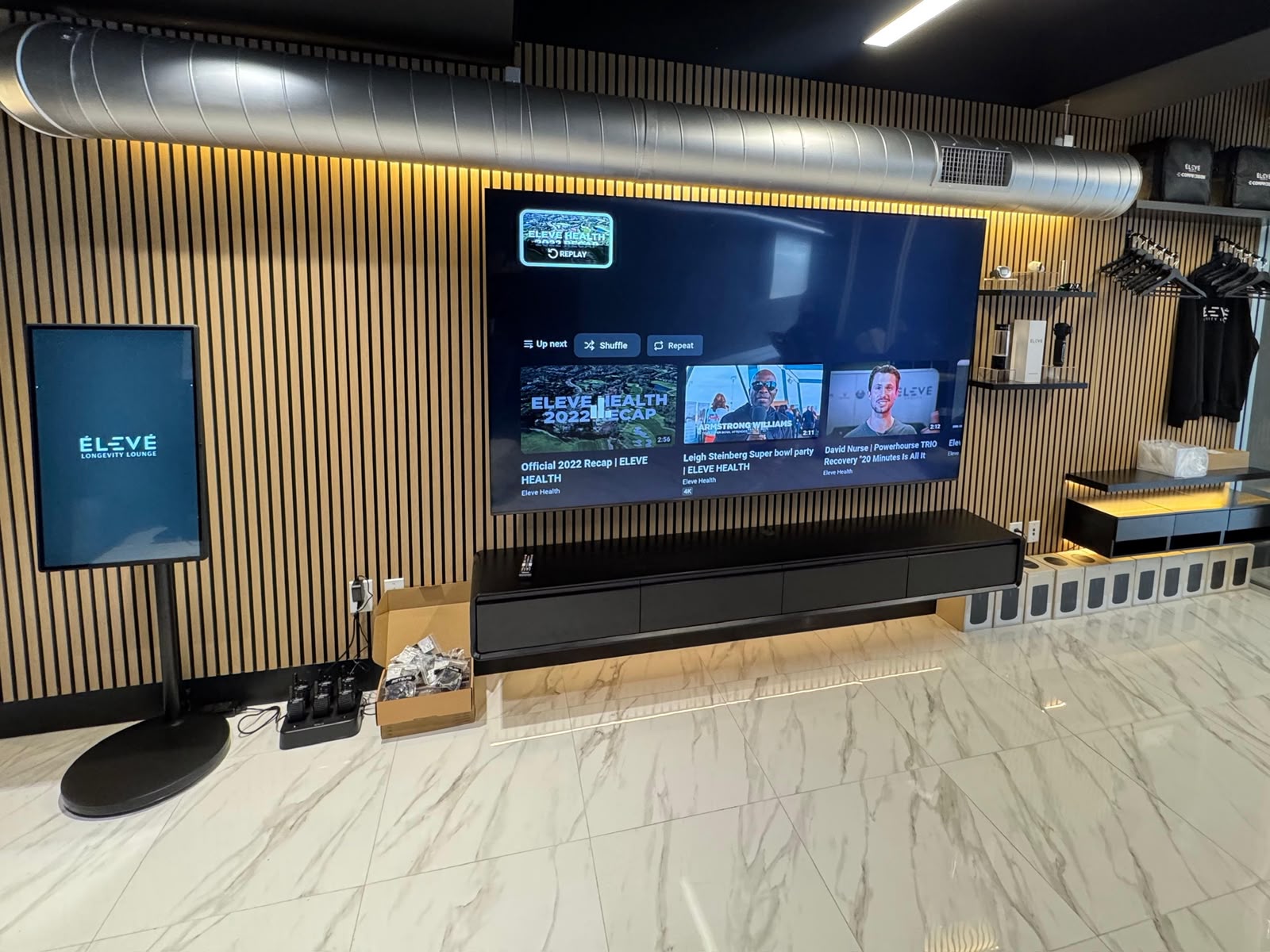 Painel ripado de madeira com televisão e rack suspenso